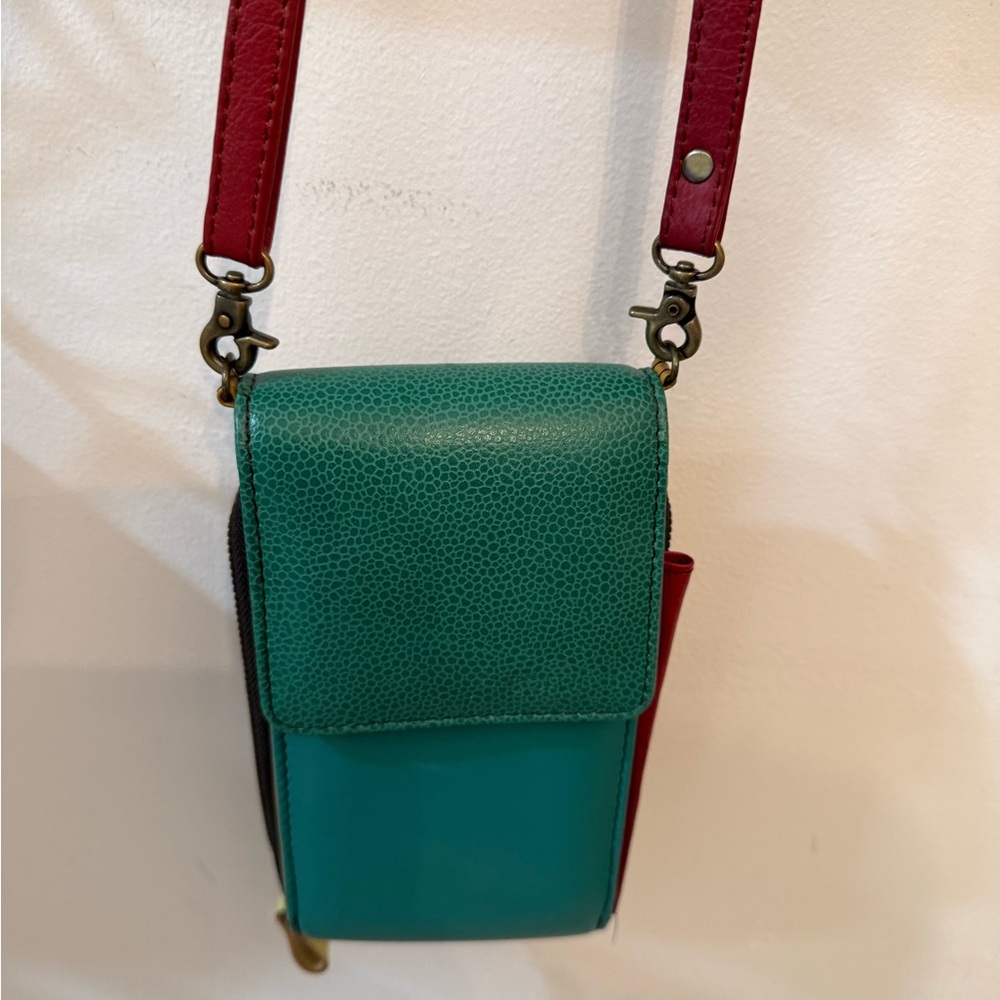 Small multicolor leather wallet with shoulder strap.